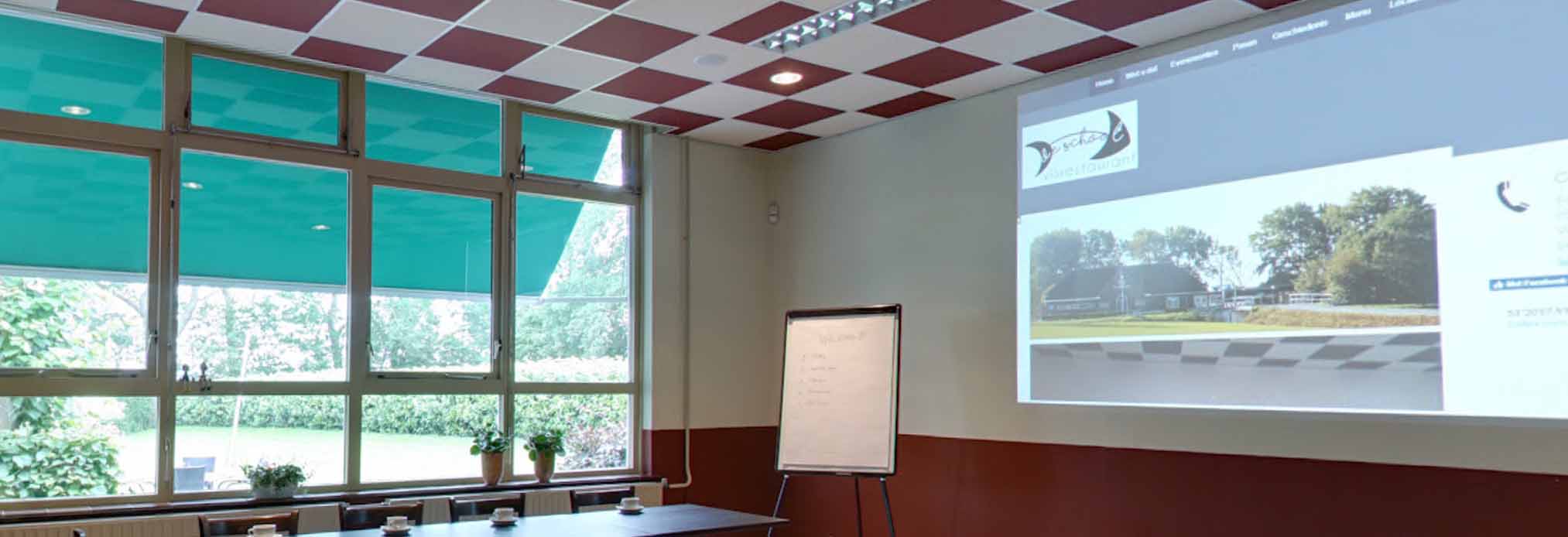 Een blik op het raam en daarnaast op de muur een blik op een projector.