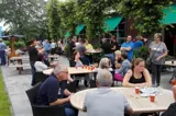 Mensen genieten van hun dag op het terras buiten Visrestaurant De School.
